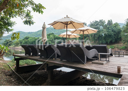 Relax chairs with parasols on dock by kwai river, Kanchanaburi Relax chairs with parasols on dock by kwai river, Kanchanaburi 106479823