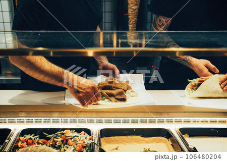 美味しいケバブロールを作る店員の手元 106480204