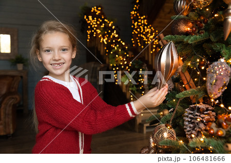 Portrait of happy cute small child girl decorating Christmas tree. 106481666