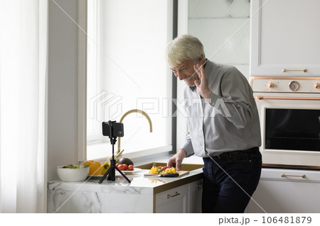 Cheerful happy mature chef blogger man filming cooking on smartphone 106481879