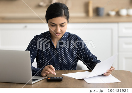 Positive focused freelance accountant woman working at home 106481922