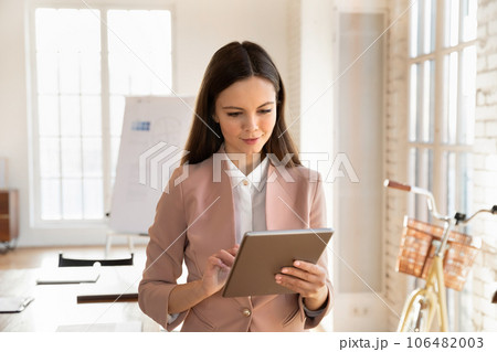 Young female employee using modern tablet in office 106482003