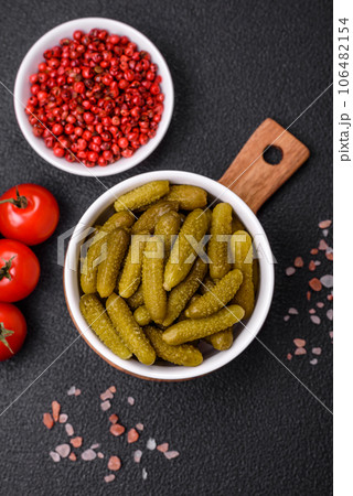 Delicious small pickled cucumbers gherkins with onions, mustard, salt and spices 106482154