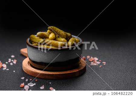 Delicious small pickled cucumbers gherkins with onions, mustard, salt and spices 106482220