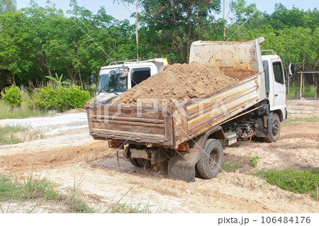 Dump truck unloading soil at construction site. Dump truck unloading soil at construction site. 106484176