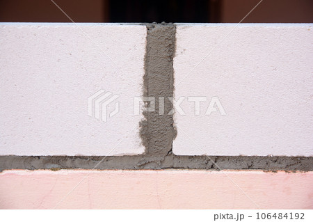 Bricklayer worker installing Lightweight Concrete on exterior wall with trowel putty knife. 106484192