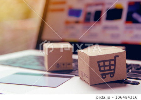 Online shopping - Paper cartons or parcel with a shopping cart logo and credit card on a laptop keyboard. Shopping service on The online web and offers home delivery.. Online shopping - Paper cartons or parcel with a shopping cart logo and credit card on a laptop keyboard. Shopping service on The online web and offers home delivery.. 106484316