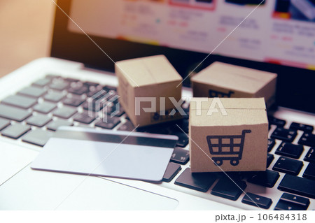 Online shopping - Paper cartons or parcel with a shopping cart logo and credit card on a laptop keyboard. Shopping service on The online web and offers home delivery.. 106484318