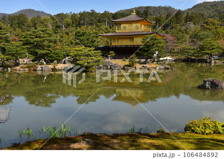 日本の春の京都　世界遺産の金閣寺　金色に輝く舎利殿　美しい青空と鹿苑寺庭園　岩に佇む大きな鳥 106484892