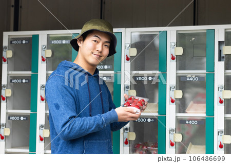 自動販売機で野菜や果物を買う男性 106486699