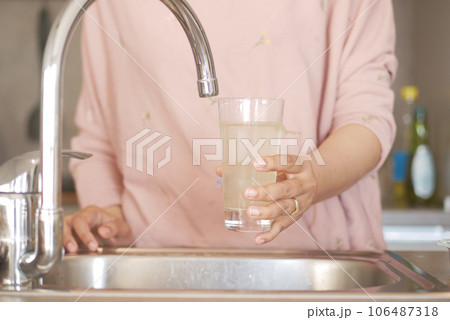 dirty water pouring from a faucet tap in a glass, dirty water pouring from a faucet tap in a glass, 106487318