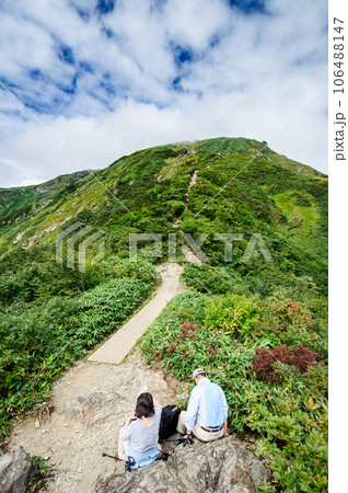 谷川岳の登山道で休憩する夫婦 106488147