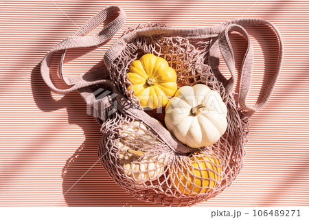 Pumpkins in net textile shopping bag. Pumpkins in net textile shopping bag. 106489271