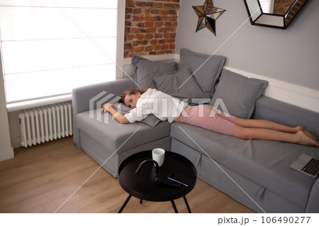 young beautiful woman lies on the sofa in the living room in the apartment young beautiful woman lies on the sofa in the living room in the apartment 106490277