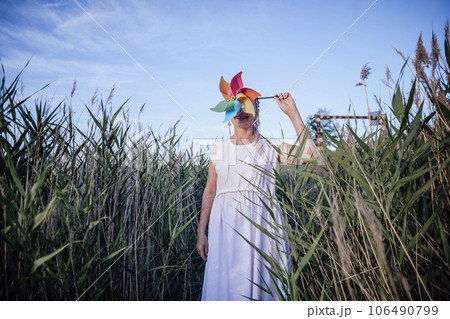 girl with unrecognizable face holds windmill , wind energy 106490799