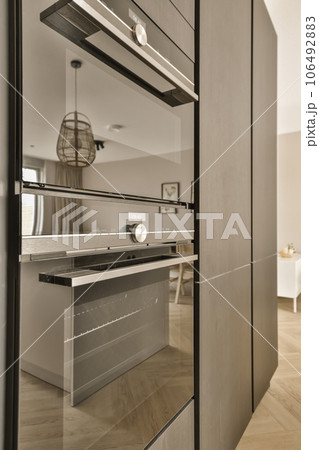 a modern kitchen with wood flooring and an oven in the middle part of the cabinetd door is open 106492883