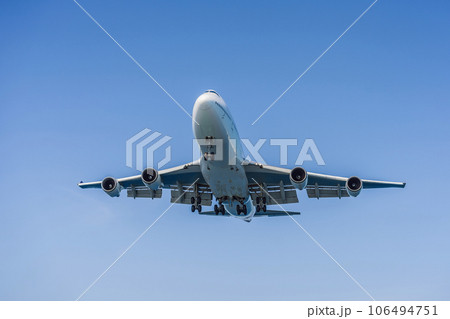 A white airplane flying in a clear pale blue sky A white airplane flying in a clear pale blue sky 106494751