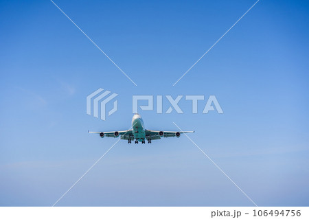 A white airplane flying in a clear pale blue sky A white airplane flying in a clear pale blue sky 106494756