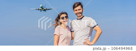Man and woman tourists have fun on the beach watching the landing planes. Traveling on an airplane concept. Text space. Island Phuket in Thailand. Impressive paradise. Hot beach Mai Khao. Amazing 106494968