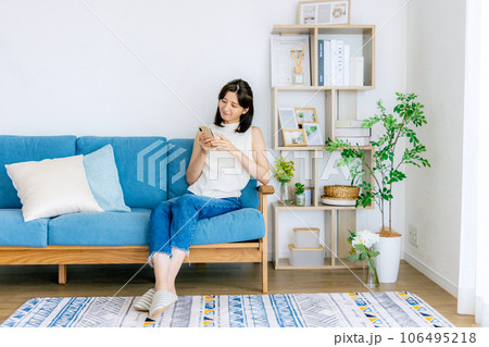 リビングでくつろぐ若い女性 スマホ リビングでくつろぐ若い女性 スマホ 106495218