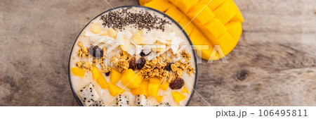 Smoothie bowls made with mango, banana, granola, grated coconut, dragon fruit, chia seeds and mint on wooden background. Concept fruits, vitamins BANNER, LONG FORMAT 106495811