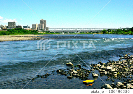 本厚木駅前を流れる相模川と、小田急電車と、駅周辺の高層住宅 106496386