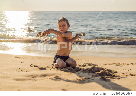 The boy screams and freaks out on the beach, throws sand. Tantrum concept The boy screams and freaks out on the beach, throws sand. Tantrum concept 106496967