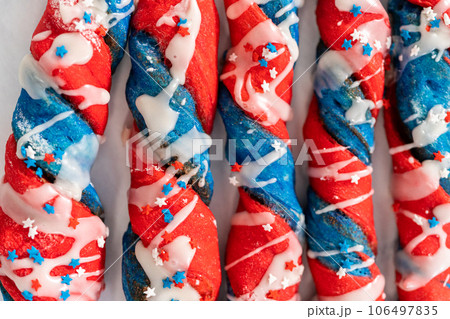Patriotic cinnamon twists drizzled with a white glaze and decorated with star sprinkles. 106497835