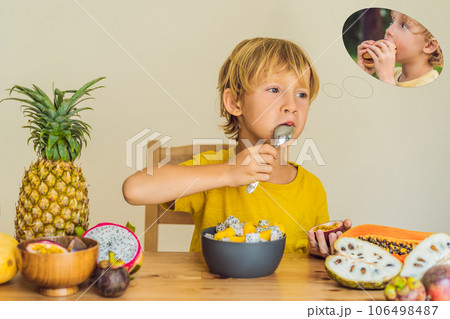 Boy eats fruit but dreams about hamburger. Harmful and healthy food for children. Child eating healthy snack. Vegetarian nutrition for kids. Vitamins for children. Junk food concept Boy eats fruit but dreams about hamburger. Harmful and healthy food for children. Child eating healthy snack. Vegetarian nutrition for kids. Vitamins for children. Junk food concept 106498487