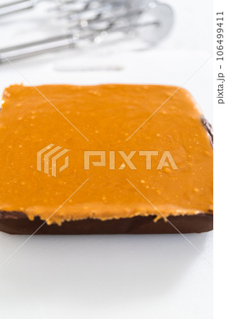 Homemade caramel fudge on a white cutting board. Homemade caramel fudge on a white cutting board. 106499411