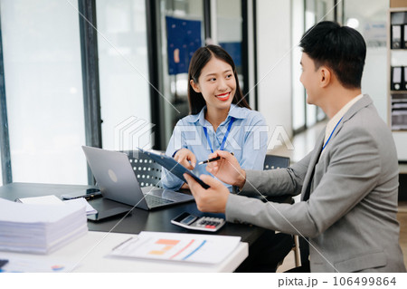 Two business workers talking on the smartphone, calculator and using laptop at the modern office.. Two business workers talking on the smartphone, calculator and using laptop at the modern office.. 106499864