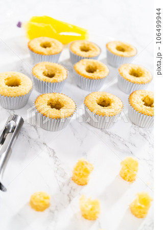 Filling lemon cupcakes with lemon filling. Filling lemon cupcakes with lemon filling. 106499944