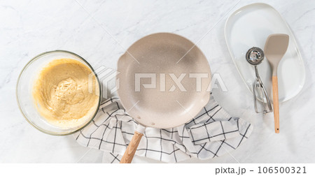Flat lay. Preparing eggnog pancakes in a nonstick frying pan. 106500321