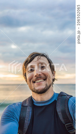 A man takes a selfie on the background of the sea and sunset VERTICAL FORMAT for Instagram mobile story or stories size. Mobile wallpaper 106502065