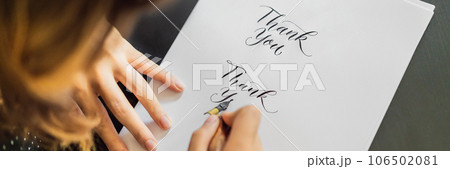 Calligrapher hands writes phrase on white paper. Phrase - Thank you. Inscribing ornamental decorated letters. Calligraphy, graphic design, lettering, handwriting, creation concept BANNER, LONG FORMAT 106502081