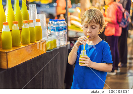 Boy drinking sugar cane juice on the Asian market 106502854