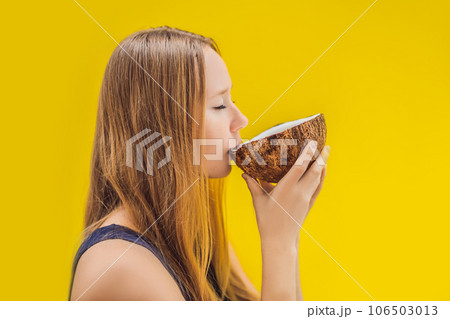 Young woman drinking coconut milk on Chafrom coconut on a yellow background Young woman drinking coconut milk on Chafrom coconut on a yellow background 106503013
