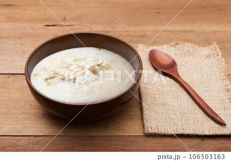 Traditional chinese porridge rice gruel in brown bowl with wooden spoon Traditional chinese porridge rice gruel in brown bowl with wooden spoon 106503163