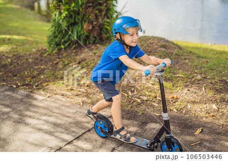 Boy riding scooters, outdoor in the park, summertime. Kids are happy playing outdoors 106503446