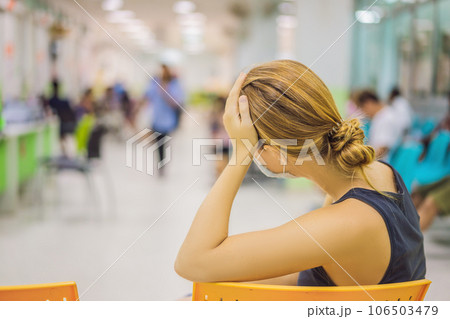Young woman sitting in hospital waiting for a doctor's appointment. Patients In Doctors Waiting Room Young woman sitting in hospital waiting for a doctor's appointment. Patients In Doctors Waiting Room 106503479