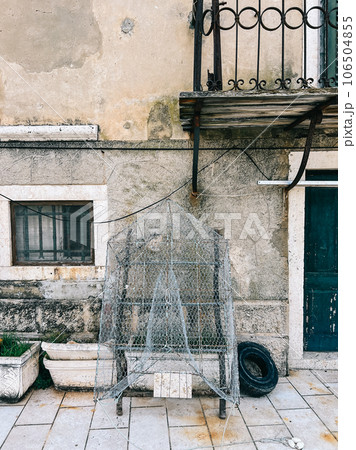 Traditional net fishing trap dries near an old stone house Traditional net fishing trap dries near an old stone house 106504855