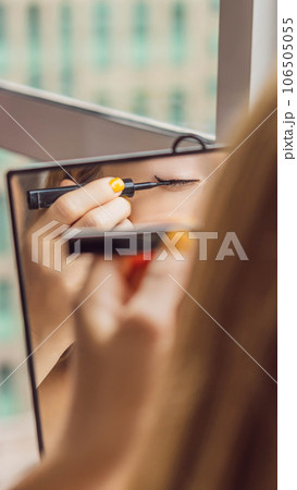 Young woman does makeup sitting by the window with a panoramic view of the skyscrapers and the big city VERTICAL FORMAT for Instagram mobile story or stories size. Mobile wallpaper Young woman does makeup sitting by the window with a panoramic view of the skyscrapers and the big city VERTICAL FORMAT for Instagram mobile story or stories size. Mobile wallpaper 106505055