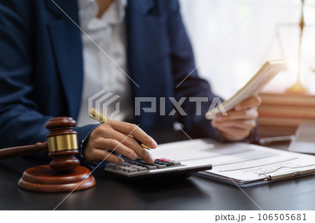 Lawyer or accounting department writes a note and uses a calculator to calculate expenses - income. at office lawyer. 106505681