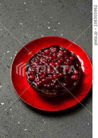 Delicious chocolate dessert with lingonberry jam on a plate on a dark background, top view Delicious chocolate dessert with lingonberry jam on a plate on a dark background, top view 106505962
