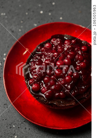 Delicious chocolate dessert with lingonberry jam on a dark background, top view 106505963
