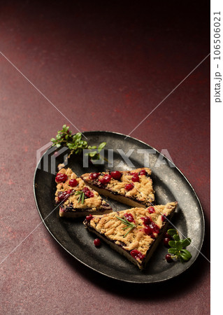 crumble with lingonberry jam on a dark tray 106506021