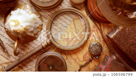 Vintage style travel and adventure. Vintage old compass and other vintage items on the table. 106506799