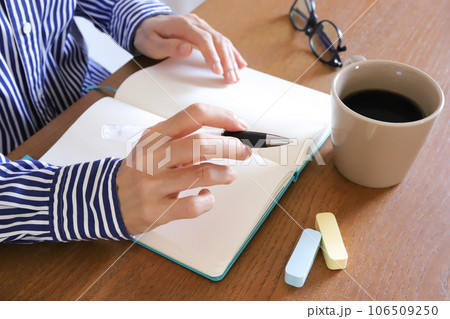 ノートとペンノートとボールペンを使う手元 106509250
