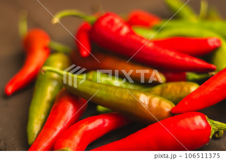 Red hot chilli peppers. Heap of red and green pepper. Bright natural background. Cayenne peppers. Colourful spicy peppers. Organic vegetables. Spicy mexican food. Red hot chilli peppers. Heap of red and green pepper. Bright natural background. Cayenne peppers. Colourful spicy peppers. Organic vegetables. Spicy mexican food. 106511375