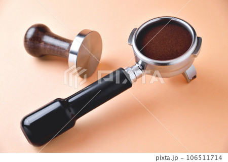 coffee horn with natural ground coffee and temper on an orange background coffee horn with natural ground coffee and temper on an orange background 106511714